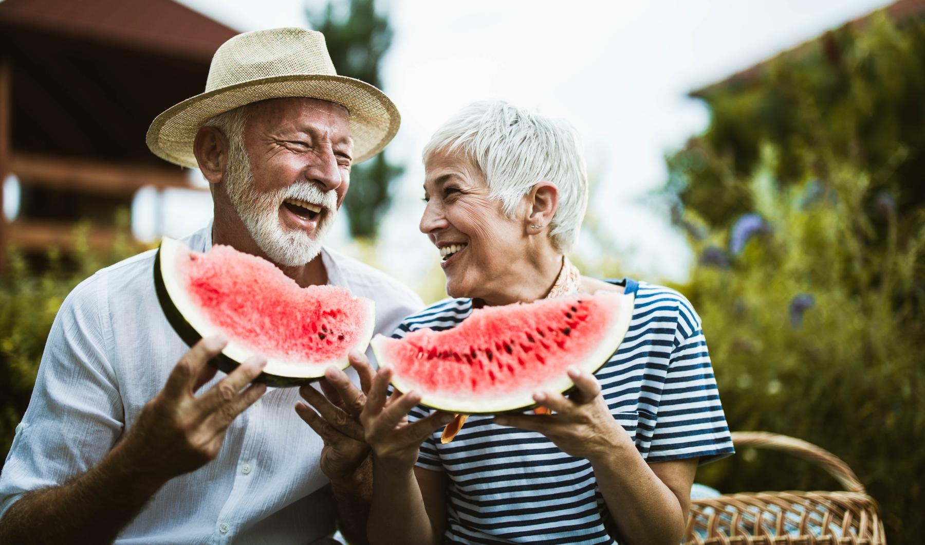 a man and a woman eating watermelon